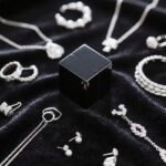 Silver jewelry collection with a black magnet cube—testing if silver is magnetic, showcasing real - world items to explore silver’s magnetic properties.