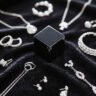 Silver jewelry collection with a black magnet cube—testing if silver is magnetic, showcasing real - world items to explore silver’s magnetic properties.