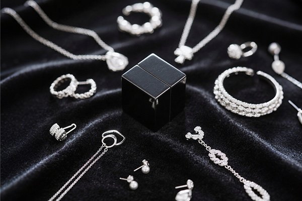 Silver jewelry collection with a black magnet cube—testing if silver is magnetic, showcasing real - world items to explore silver’s magnetic properties.